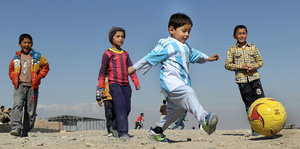 Vier Kinder spielen Fußball