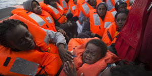 Flüchtlinge in Schwimmwesten an Deck eines Schiffes