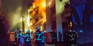 Feuerwehr im Einsatz vor einem brennenden Haus