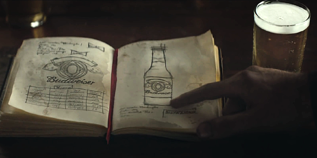 Ein Finger zeigt auf ein Buch mit einer Zeichnung von einer Bierflasche