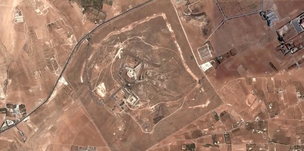 Eine Luftaufnahme zeigt ein Gelände auf sandigem Boden