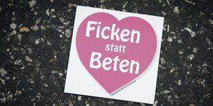 Ein Sticker, auf dem „Ficken statt beten“ steht