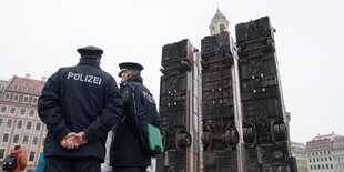 Polizisten vor einer Skulptur