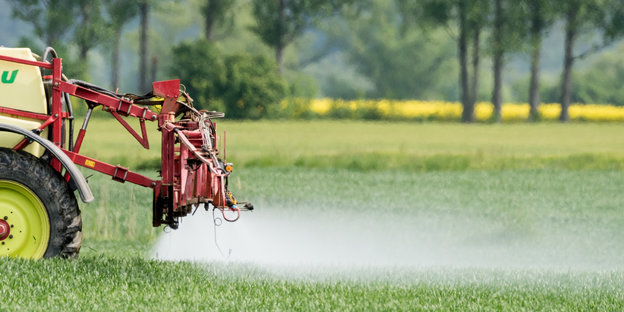 Ein Landwirt fährt mit einer Dünger- und Pestizidspritze über sein Feld