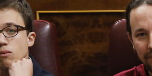 Pablo Iglesias und Inigo Errejon sitzen nebeneinander im Parlament und gucken beide nach vorne