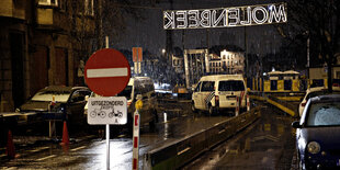 Polizeifahrzeuge stehen hinter einem Sperrschild im Stadtteil Molenbeek