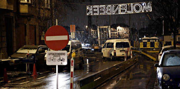 Polizeifahrzeuge stehen hinter einem Sperrschild im Stadtteil Molenbeek