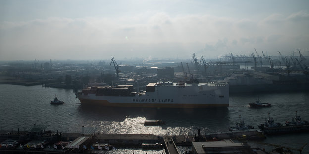 Ein Autotransporter der Grimaldi Lines fährt an den Landungsbrücken in Hamburg mit Schlepperunterstützung über die Elbe in den Hafen ein