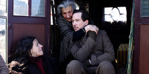 Der Schauspieler Reda Kateb, umarmt von einer älteren Frau, von unten betrachtet von einer jüngeren Frau in einer Szene im Film "Django"