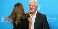 Richard Gere umarmt eine Frau, die man nur von hinten sieht