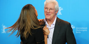 Richard Gere umarmt eine Frau, die man nur von hinten sieht