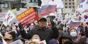 Unterstützer der entmachteten südkoreanischen Präsidentin Park Geun-hye halten Plakate und Fahnen in Seoul