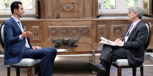 Baschar al-Assad und ein Reporter sitzen sich gegenüber