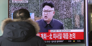 Ein Mensch schaut auf einen Bildschirm, der Nordkoreas Diktator Kim Jong Un zeigt
