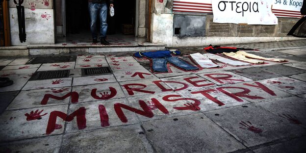 Auf dem Straßenboden steht "Murder Ministry" - Mörderministerium"