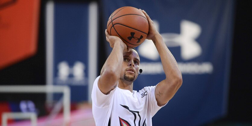 Stephen Curry zielt mit Ball in der Hand auf den Korb