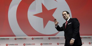 Tunesiens Premierminister Youssef Chahed vor der Nationalflagge