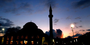 Die Silhouette ener Moschee vor der untergehenden Sonne.