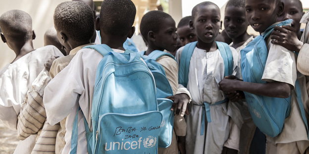 Eine Gruppe afrikanischer Kinder mit blauen UNO-Schulranzen
