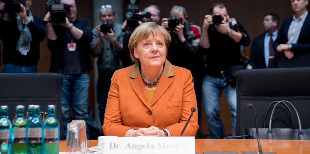 Angela Merkel sitzt in einem Raum
