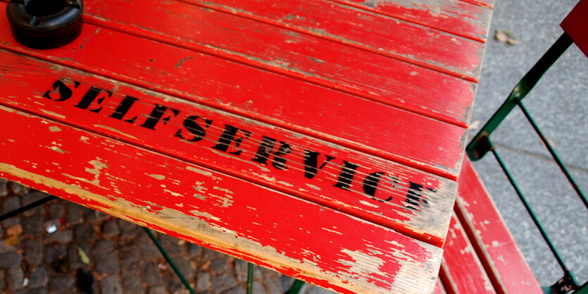 Auf einem Tisch steht ein Aschenbecher und „Selfservice“