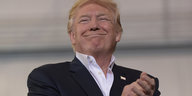Donald Trump lächelt und hat die Hände ineinander gelegt
