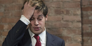 Ein Mann im Anzug fährt sich mit rechten Hand durch die Haare. Es ist Milo Yiannopoulos