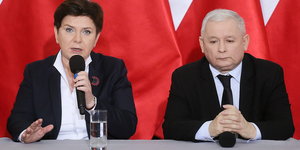 Polens Premierministerin Beata Szydlo mit PiS-Pateichef Jaroslaw Kaczynski an einem Tisch vor rotem Hintergrund