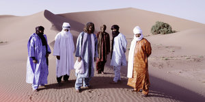 Die Band Tinariwen steht auf einer Sanddüne im Süden Marokkos