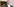 Ein Mann in Anzug und Hemd von unten fotografiert, im Hintergrund ein Gemälde