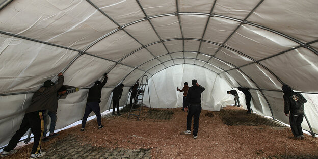 Menschen bauen ein großes Zelt auf