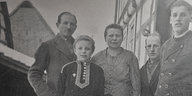 Ein schwarz-weißes Familienfoto zeigt Eltern und drei Kindern