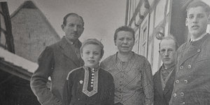 Ein schwarz-weißes Familienfoto zeigt Eltern und drei Kindern