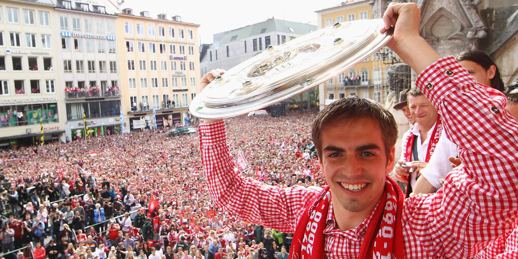 Philipp Lahm hält auf dem Rathaus-Balkon in München bei der Meisterfeier des FC Bayern 2010 die Meisterschale hoch