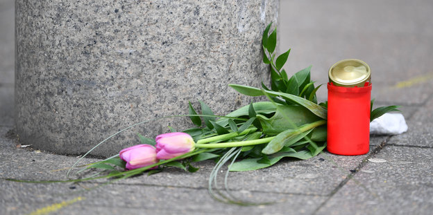 zwei Tulpen und ein Friedhofslicht vor einem Granitsockel auf dem Boden