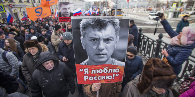 Menschen demonstrieren mit Nemzow-Plakaten