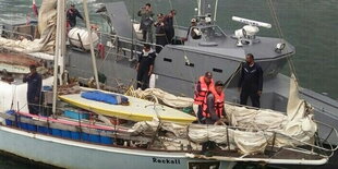 Männer in Uniformen stehen auf einem Schiff