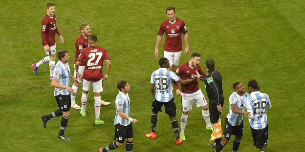 Fußballer in roten und weiß-blauen Trikots streiten sich