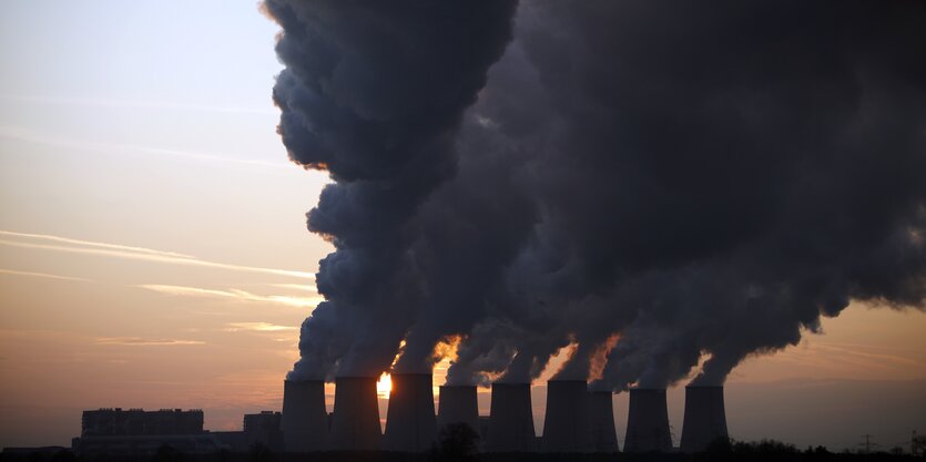 Große Industrieanlage mit Riesenschornsteinen, aus denen Dampfwolken steigen