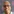 Ein Mann mit Brille lächelt, im Hintergrund Amnesty-Symbole
