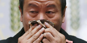 Ein weinender Mann putzt sich mit einem Taschentuch die Nase
