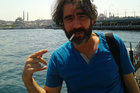 Deniz Yücel mit Zigarette im Mundwinkel, seine Haare wehen im Wind