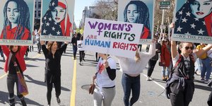 Frauen protestieren mit Plakaten für Frauenrechte