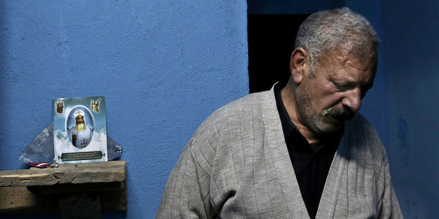 Ezzat Yaacoub Ishak steht vor einer blauen Wand in einem Appartment