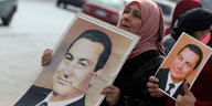 Zwei Frauen tragen Mubarakbilder vor sich her