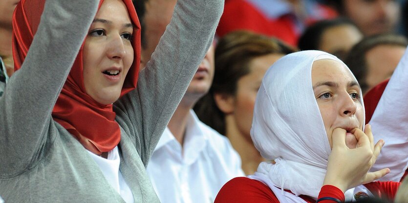 Frauen im Kopftuch jubeln auf der Tribüne den Basketball-Spielerinnen zu