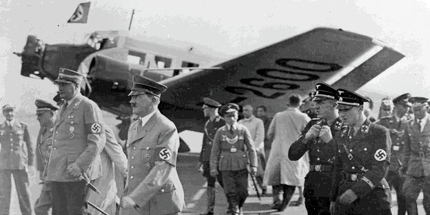 Hitler und weitere Nazis vor einem Flugzeug in schwarz-weiß