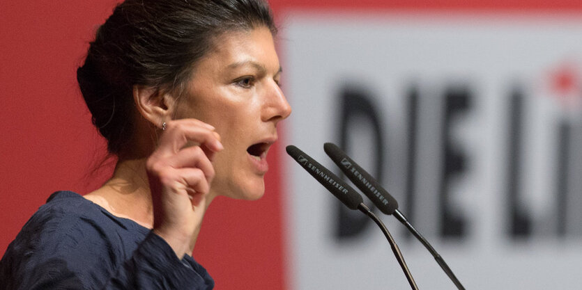 Sarah Wagenknecht steht gestikulierend am Mikrofon