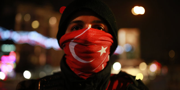 Ein Besucher des Neujahr-Festes trägt am 01.01.2016 in Istanbul (Türkei) im Ortakoy Viertel einen Schal mit türkischer Flagge.