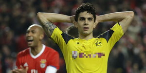 ein Mann im gelben Dortmund-Trikot mit hinter dem Kopf verschränkten Armen, im Hintergrund ein jubelnder Benfica-Spieler im roten Trikot